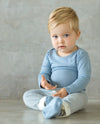 baby wearing blue long sleeve top and drawstring pants