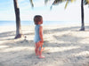 baby wearing merino singlet bodysuit by the beach