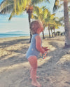 baby wearing merino singlet bodysuit by the beach