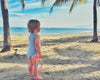 baby wearing merino singlet bodysuit by the beach